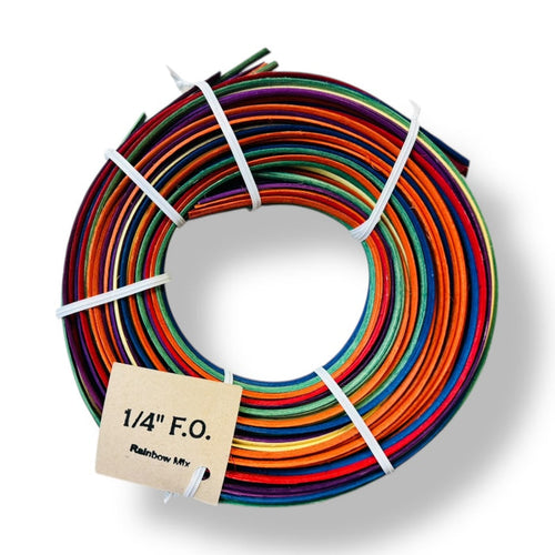 Spool of Rainbow mix colored reeds with a label tag on a white backdrop with shadow.