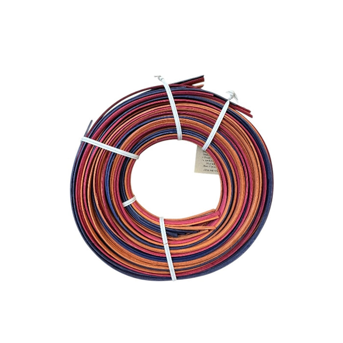 Coiled multicolored reeds on a white background showcasing the backside colors of the coil