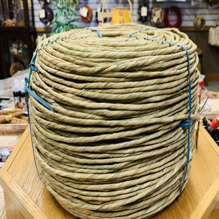 Ten pound coil of 4-5mm pre twisted natural rush from HH Perkins on table in the product showroom.