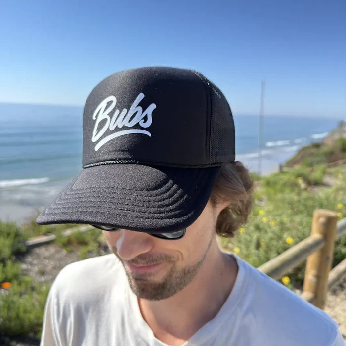Person wearing a BUBS Black Trucker Hat outdoors