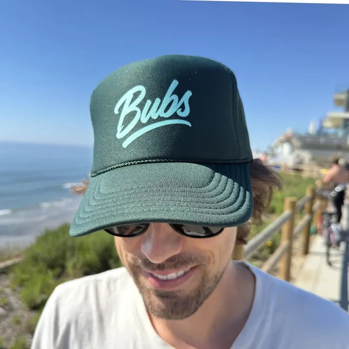 Person wearing a BUBS Forest Trucker Hat outdoors