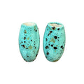 Two turquoise ceramic basket handles with speckled pattern on a white background