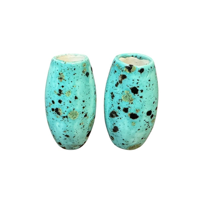 Two turquoise ceramic basket handles with speckled pattern on a white background