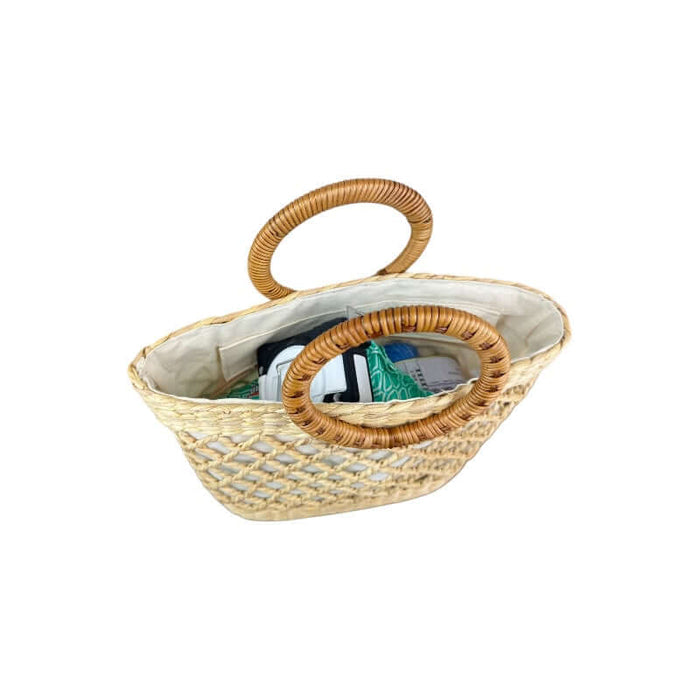 Open straw tote bag with contents inside to show the inside and the amount you can fit inside the handbag.