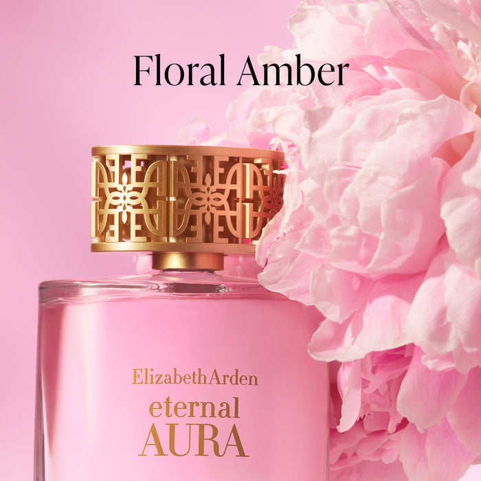 Close-up of Eternal Aura Eau de Parfum bottle with pink floral background