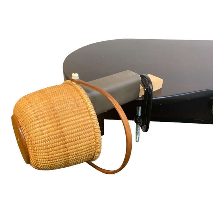 Leather covered hammer block fastened to the table with a c-clamp and a basket on the end.