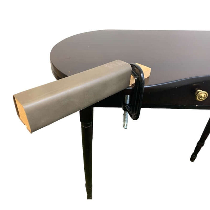 Large leather covered hammer block attached to the table with c-clamp.