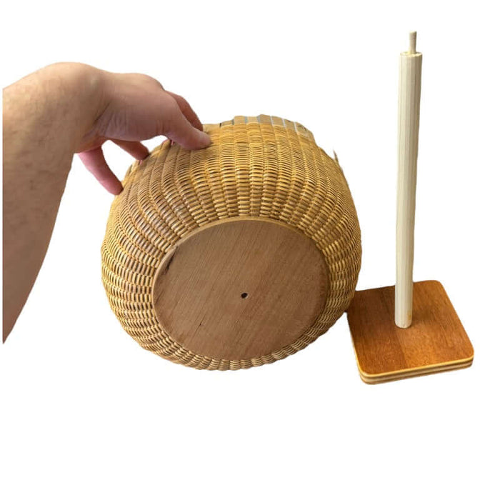 Basket being held to show hole in the cherry base that will be inserted onto the Nantucket Basket drying stand.