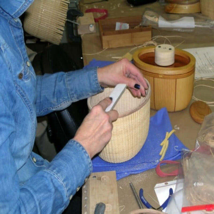 Nantucket Basket weaver filing basket rim after detaching it from mold stand.