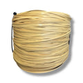 Large spool of new plastic strand cane for seat weaving on a white background