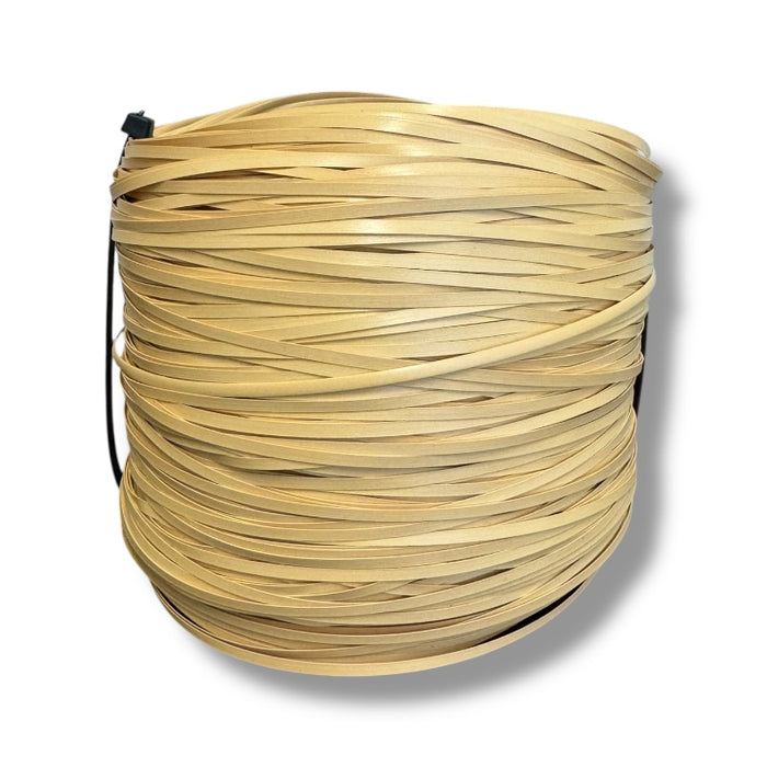 Large spool of new plastic strand cane for seat weaving on a white background