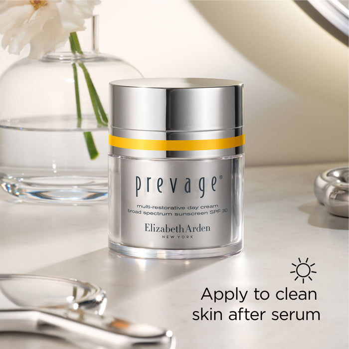 Elizabeth Arden Prevage cream jar on a reflective surface with decorative elements.