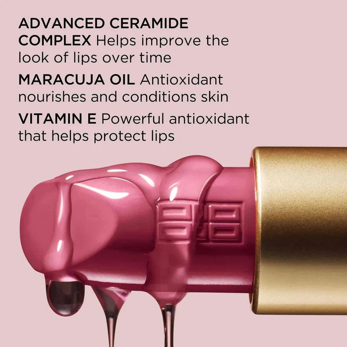 Pink lip balm with gold cap on a pink background, featuring text about its ingredients.