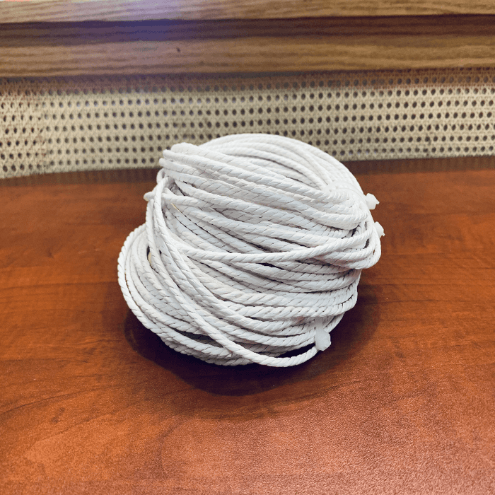White Unlaced Danish Paper Cord 1 pound coil on the HH Perkins clasroom table with Cane webbing in the background.